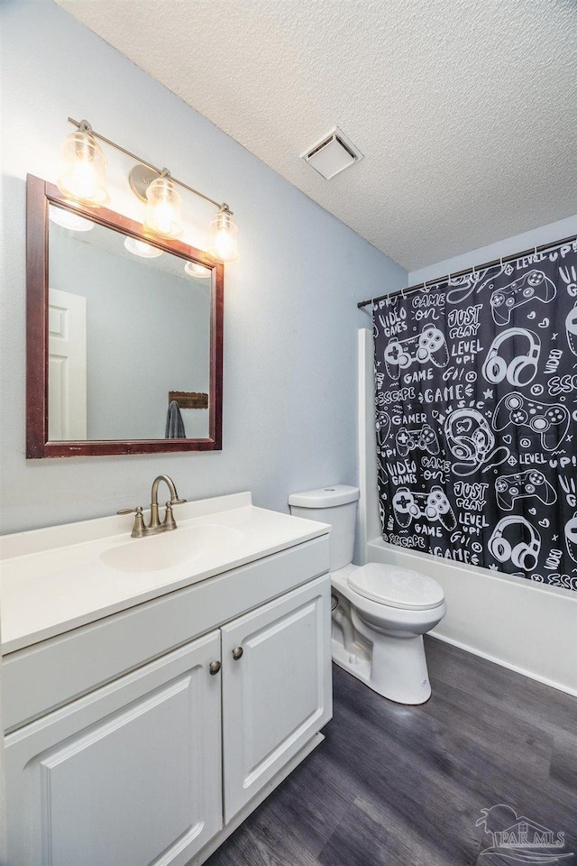 2000 Silverado Rd, Pensacola, FL 32506 - full bathroom featuring vanity, wood finished floors, toilet, a textured ceiling, and shower / bathtub combination with curtain