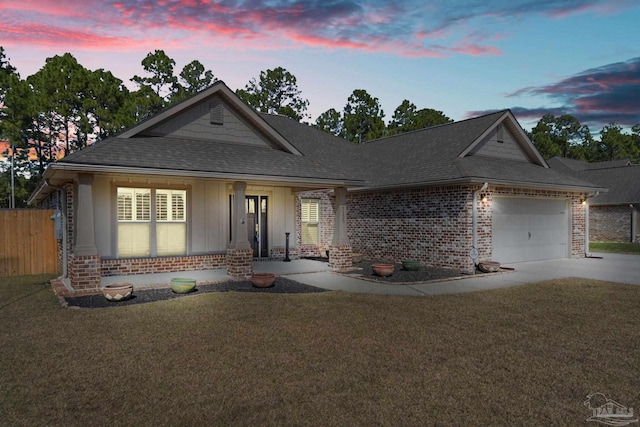 view of front facade featuring an attached garage, brick siding, driveway, roof with shingles, and a front lawn