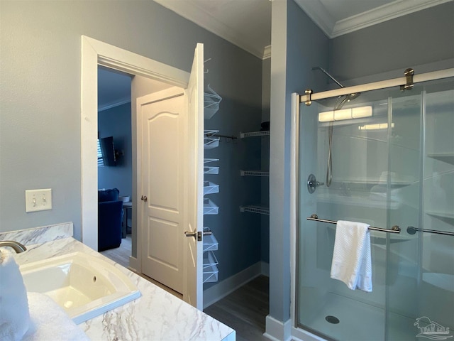 bathroom with ornamental molding, hardwood / wood-style floors, vanity, and a shower with shower door