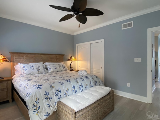 bedroom featuring hardwood / wood-style floors, crown molding, a closet, and ceiling fan