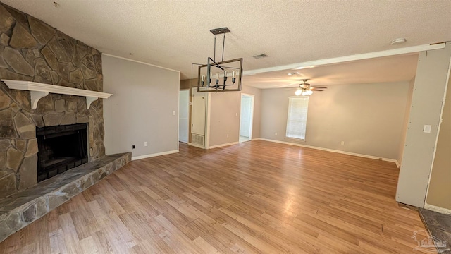 unfurnished living room featuring ceiling fan, light hardwood / wood-style flooring, a textured ceiling, and a fireplace