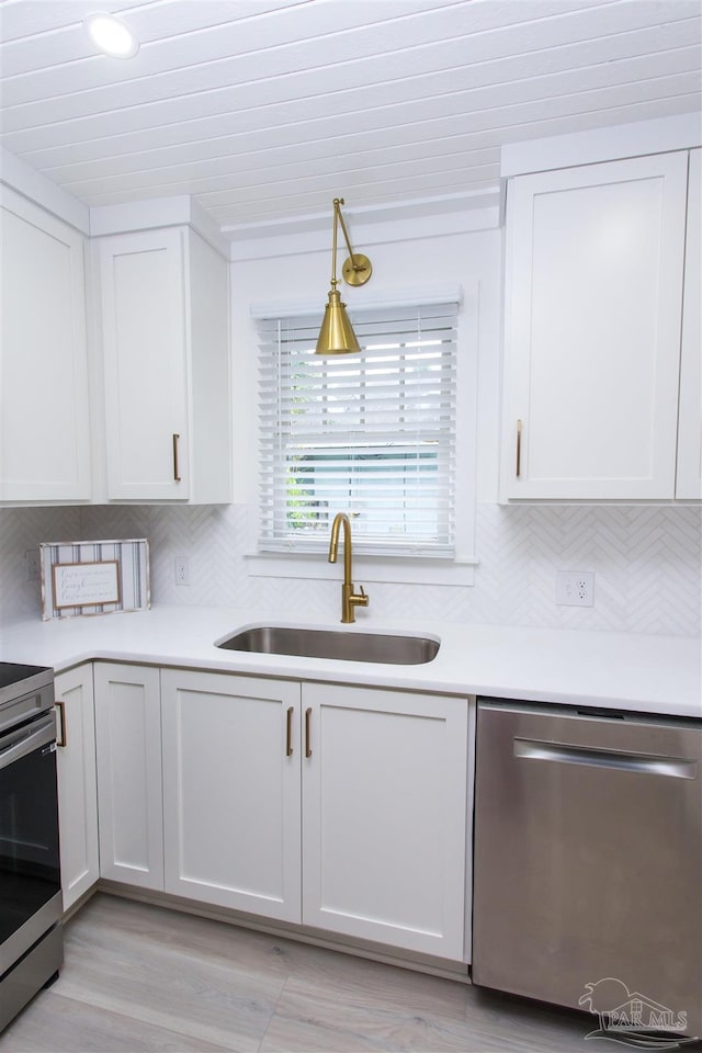 kitchen featuring light wood-type flooring, white cabinets, stainless steel appliances, and sink