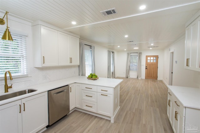 kitchen with visible vents, a peninsula, a sink, white cabinets, and dishwasher
