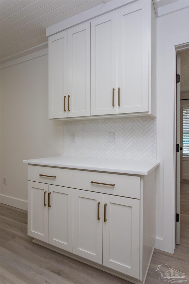 interior details featuring tasteful backsplash, baseboards, and wood finished floors