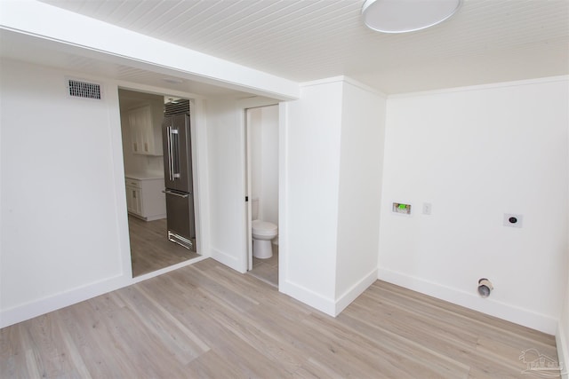 washroom with electric dryer hookup, visible vents, light wood-type flooring, and baseboards