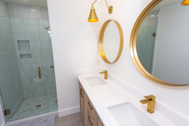 bathroom with double vanity, baseboards, a stall shower, and a sink