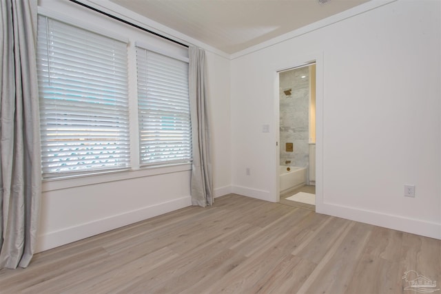 empty room with light hardwood / wood-style floors and ornamental molding