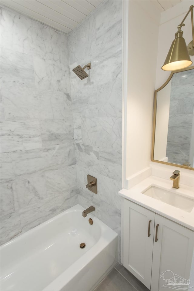 bathroom featuring tile patterned flooring, vanity, and tiled shower / bath combo