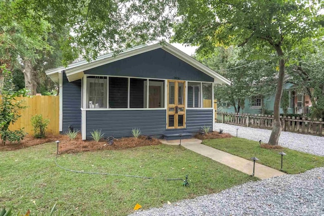 bungalow-style home with a sunroom and a front yard