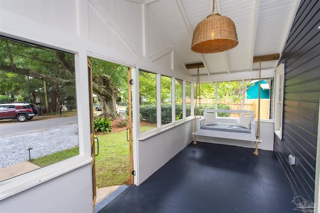 unfurnished sunroom with lofted ceiling with beams