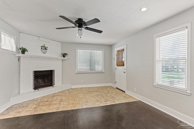 unfurnished living room featuring hardwood / wood-style floors, a fireplace, and ceiling fan