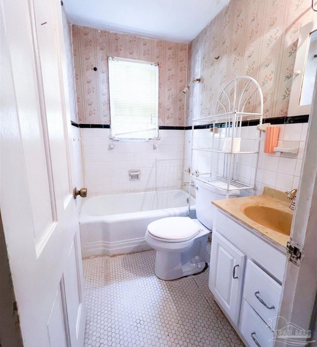 bathroom with vanity, tile walls, and toilet