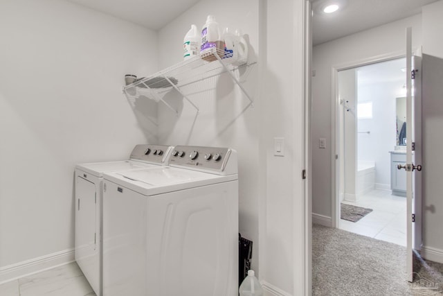 washroom with baseboards, independent washer and dryer, laundry area, and light carpet