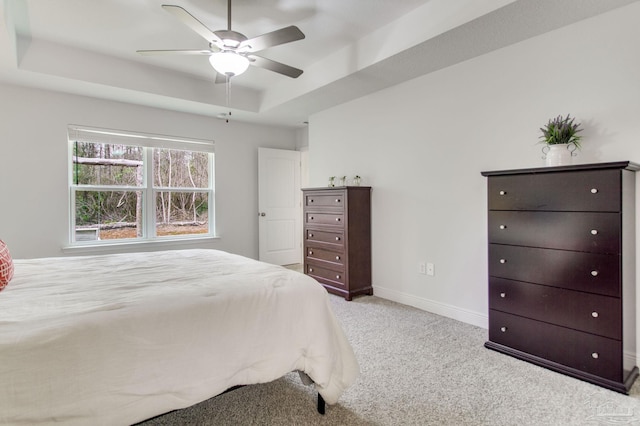 bedroom with baseboards, a raised ceiling, carpet floors, and ceiling fan