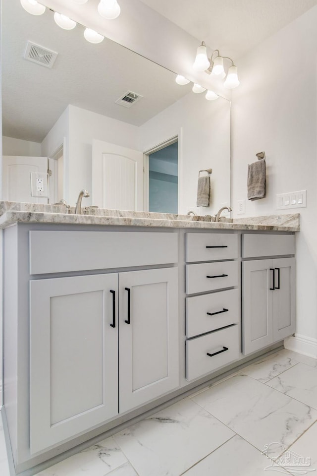 bathroom featuring visible vents, marble finish floor, and double vanity