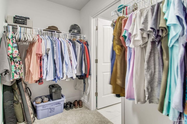 walk in closet with marble finish floor