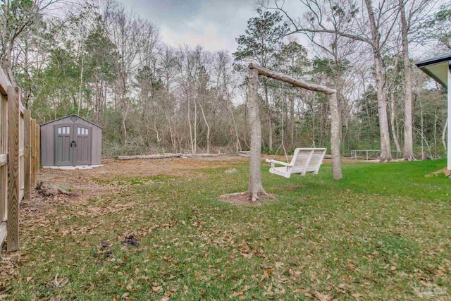 view of yard featuring an outbuilding, a storage unit, and fence