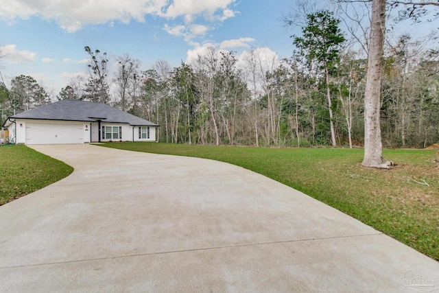 view of front of home featuring a front yard, an attached garage, driveway, and stucco siding