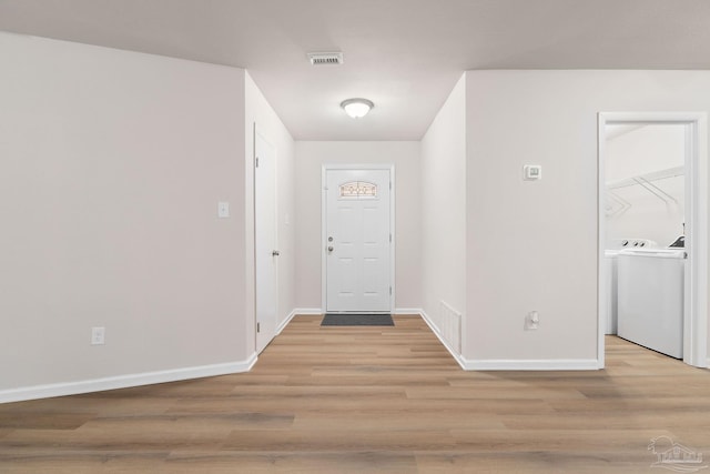 entrance foyer featuring light hardwood / wood-style flooring and washing machine and clothes dryer