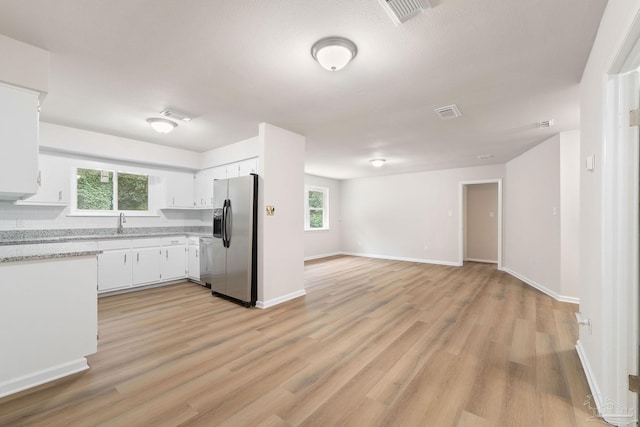 kitchen with white cabinetry, stainless steel appliances, light hardwood / wood-style floors, and plenty of natural light