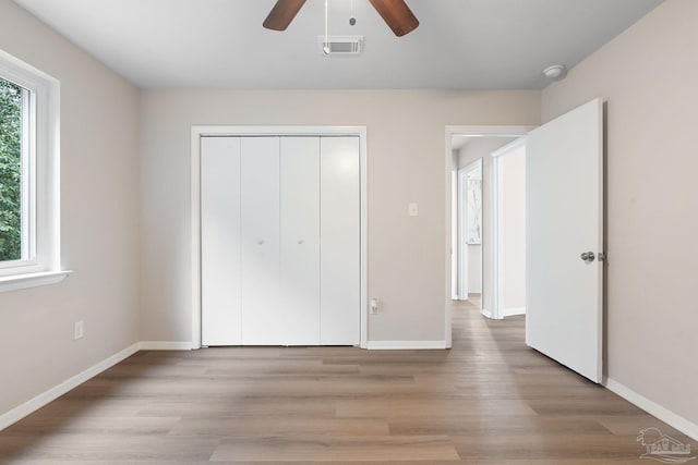 unfurnished bedroom with light hardwood / wood-style floors, a closet, and ceiling fan