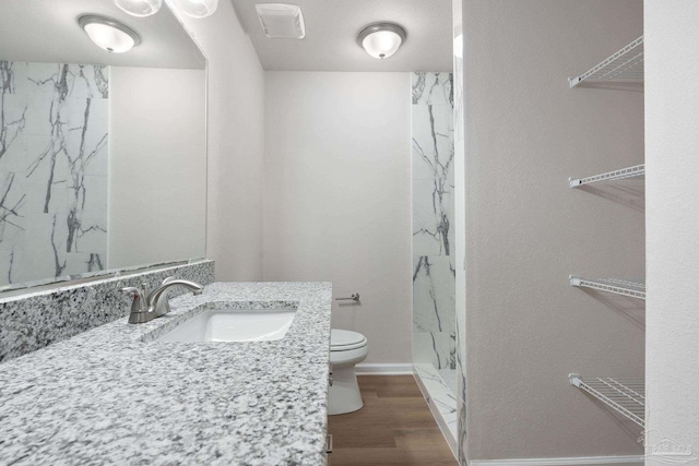 bathroom with a shower, wood-type flooring, vanity, and toilet