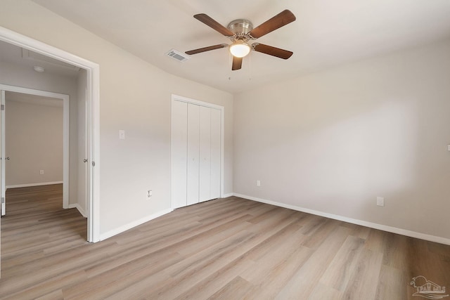 unfurnished bedroom with ceiling fan, light hardwood / wood-style floors, and a closet