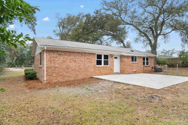 rear view of property featuring a yard and a patio area