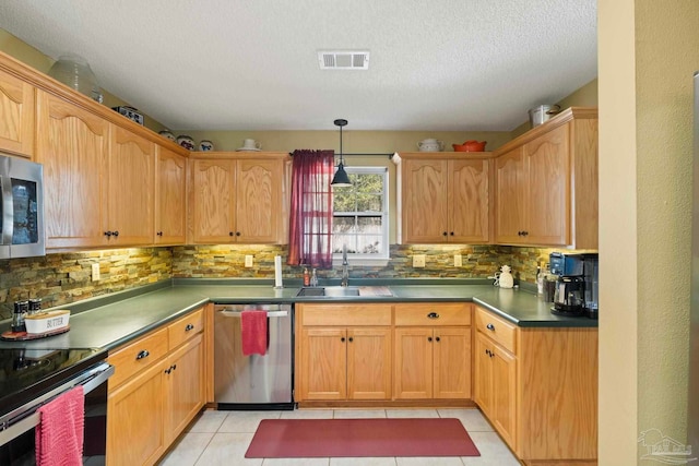 kitchen featuring tasteful backsplash, visible vents, light tile patterned flooring, stainless steel appliances, and a sink