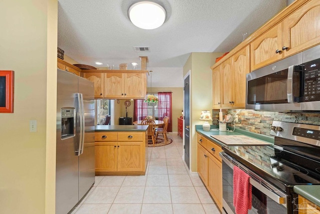 kitchen with light tile patterned floors, visible vents, appliances with stainless steel finishes, dark countertops, and backsplash