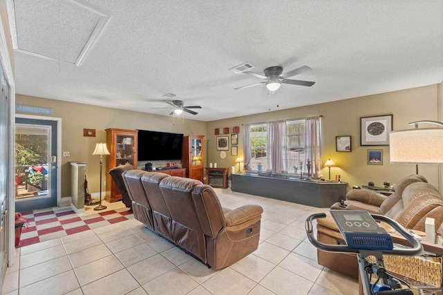 living room featuring visible vents, attic access, light tile patterned flooring, ceiling fan, and a textured ceiling