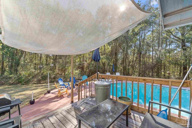 wooden terrace with an outdoor pool and outdoor dining area