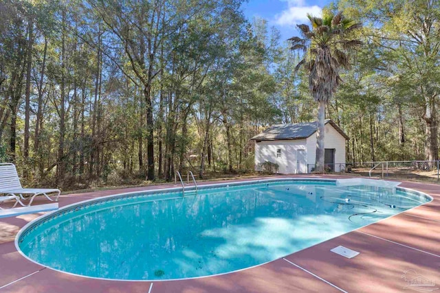 pool featuring an outbuilding and fence