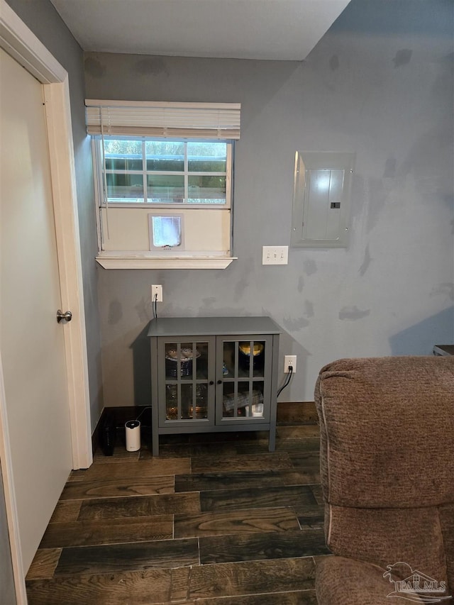 interior space featuring electric panel, baseboards, and wood finished floors