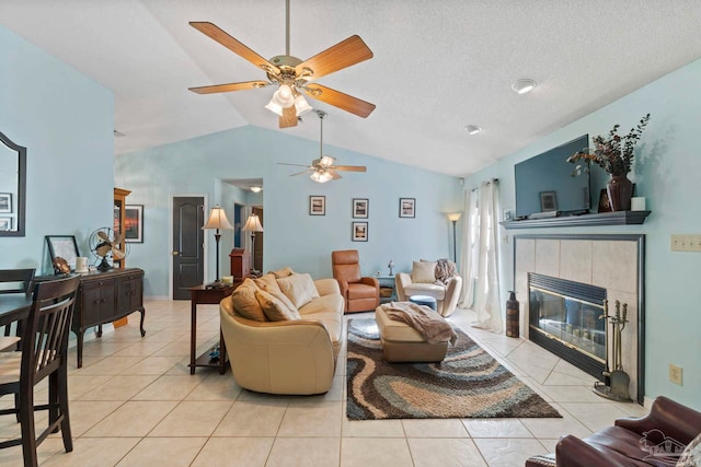 living room featuring a textured ceiling, tile patterned floors, lofted ceiling, and a tile fireplace