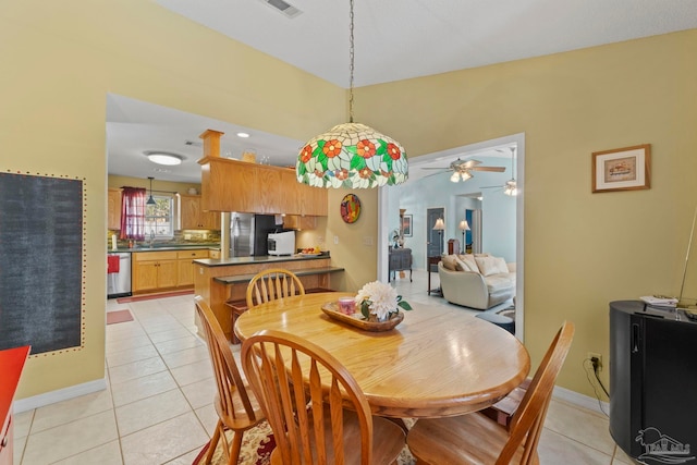 dining space with light tile patterned floors, visible vents, baseboards, and ceiling fan