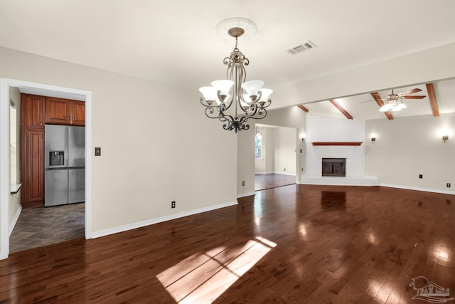 unfurnished living room featuring vaulted ceiling with beams, a fireplace, dark wood-type flooring, and ceiling fan with notable chandelier