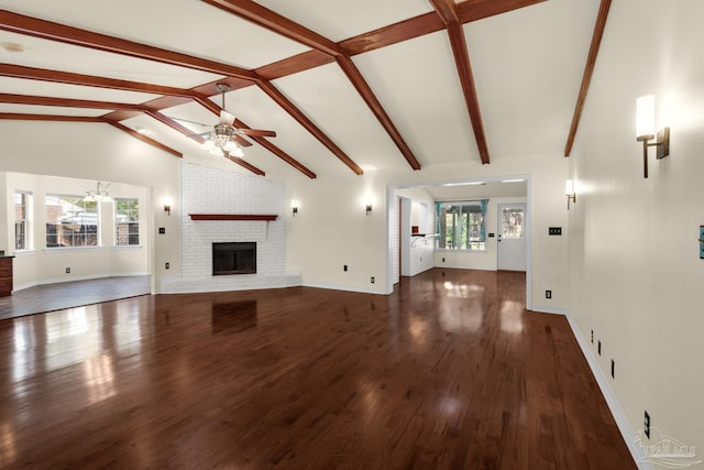 unfurnished living room featuring ceiling fan, a fireplace, a wealth of natural light, and dark wood-type flooring