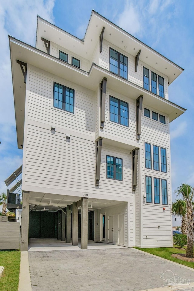 exterior space featuring decorative driveway and a carport