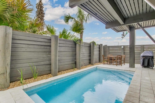 view of swimming pool with a patio area, outdoor dining area, and a fenced backyard