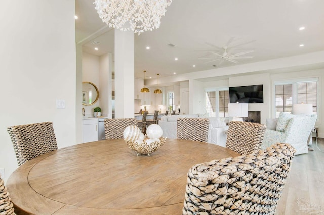 dining area featuring ceiling fan with notable chandelier, recessed lighting, and wood finished floors