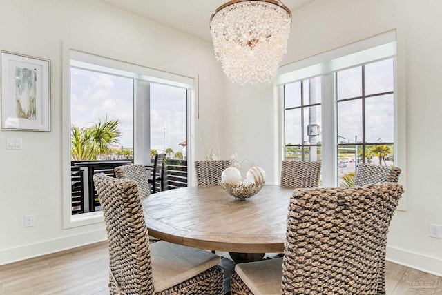 dining area with a chandelier, a healthy amount of sunlight, and light wood-style flooring