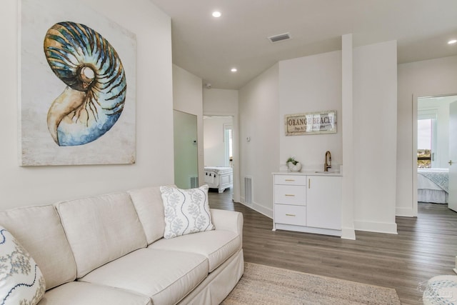 living area with visible vents, recessed lighting, and wood finished floors