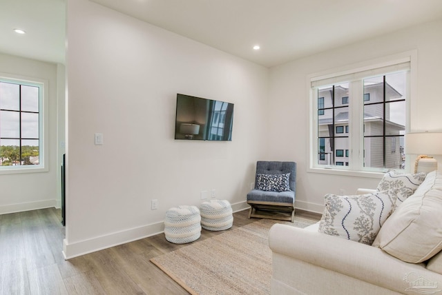 living area with recessed lighting, baseboards, and wood finished floors