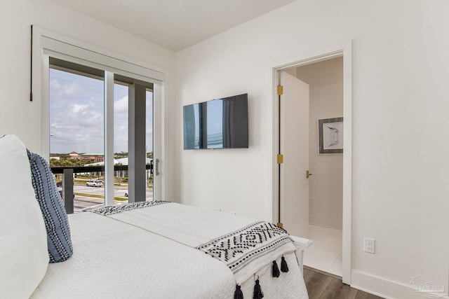 bedroom featuring dark wood-type flooring, access to outside, and baseboards