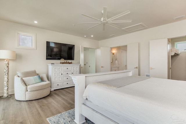 bedroom with attic access, multiple windows, visible vents, and light wood finished floors