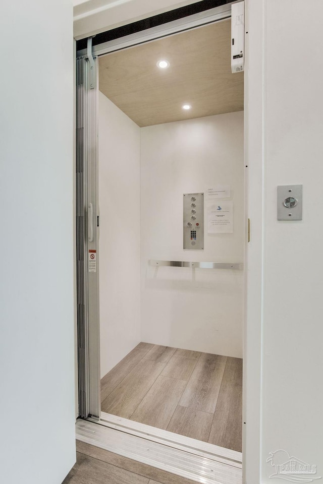 interior space featuring elevator, recessed lighting, and wood finished floors