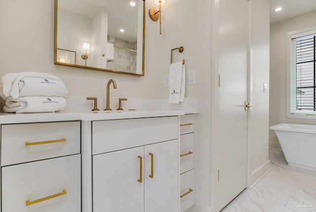 bathroom with vanity, recessed lighting, marble finish floor, and a freestanding bath