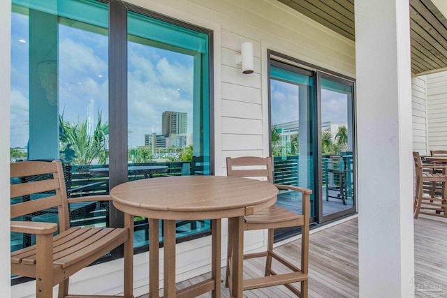 dining room featuring a city view, a healthy amount of sunlight, wood finished floors, and wood walls