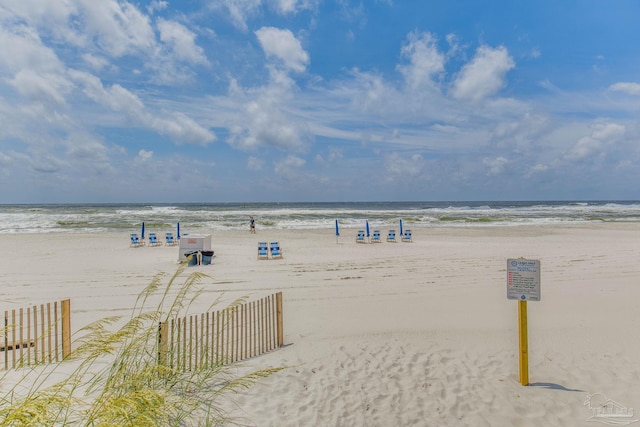 view of water feature with a view of the beach and fence